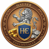 erstelle mir ein Logo für Edelmetall Händler mit dem Namen Hauser Edelmetalle. Es soll die Rahmen einer Münze haben, im Inneren soll ein Löwe in silber mit Lorbeerkranz erscheinen und davor ist ein Wappen mit den Initialien HE zusehen. Neben dem Wappen ist auf der linken Seite ein Stapel aus Goldbarren und auf der rechten Seite ein Stapel Silbermünzen.